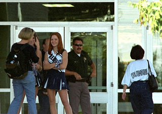 An armed police officer stands guard over a group of Columbine
cheerleaders.